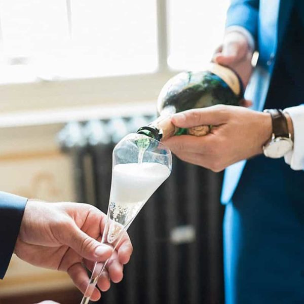 photographe de mariage sur Bordeaux lors des préparatifs du marie au château de la ligne à Lignan de Bordeaux avec une coupe de champagne en détails