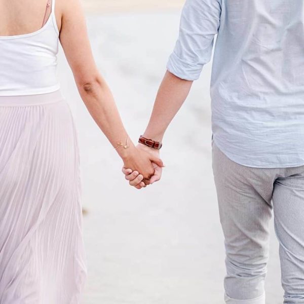 seance couple sur le bassin d'Arcachon ou l'on voit le détails des mains sur un couple en train de marcher au bord de l'eau avec des photos réalisé par un photographe professionnel