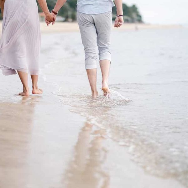 détails des pieds lors d'une seance couple sur arcachon ou les futurs mariés sont en train de marcher dans l'eau