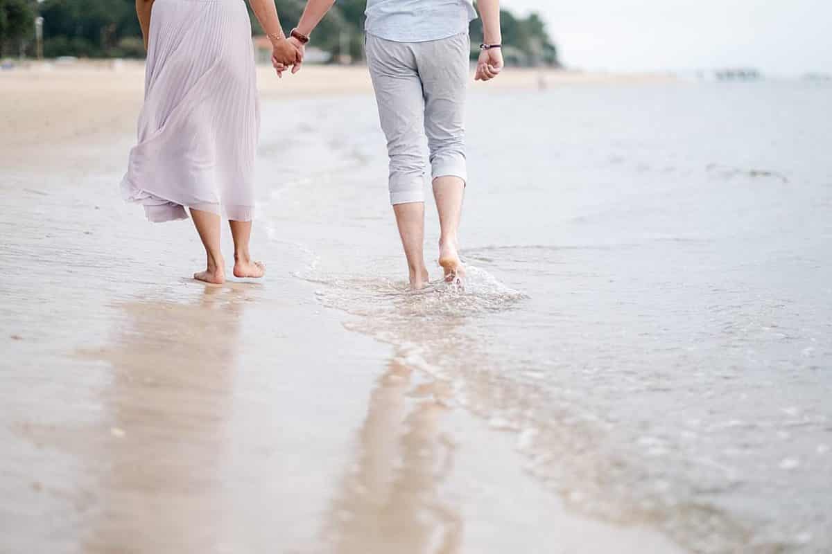 détails des pieds lors d'une seance couple sur arcachon ou les futurs mariés sont en train de marcher dans l'eau