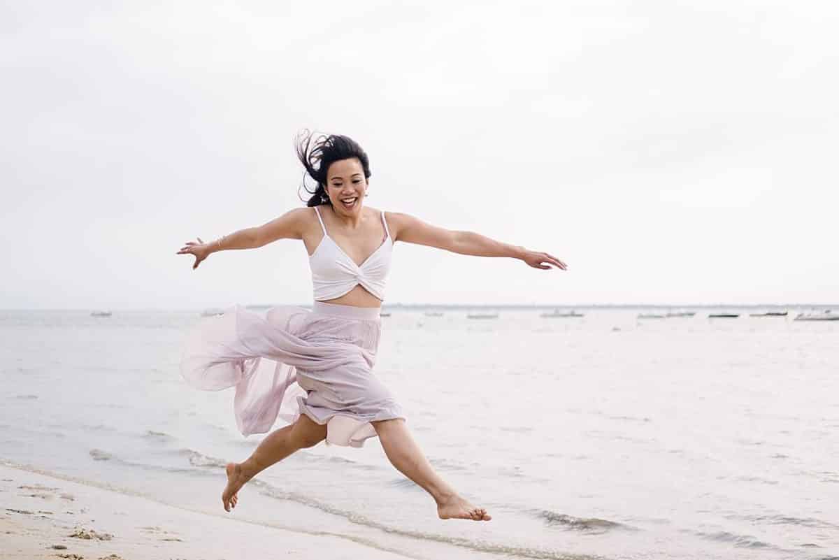 seance couple sur arcachon ou la future mariée s'est mise à sauter en faisant le grand écart dans le sable