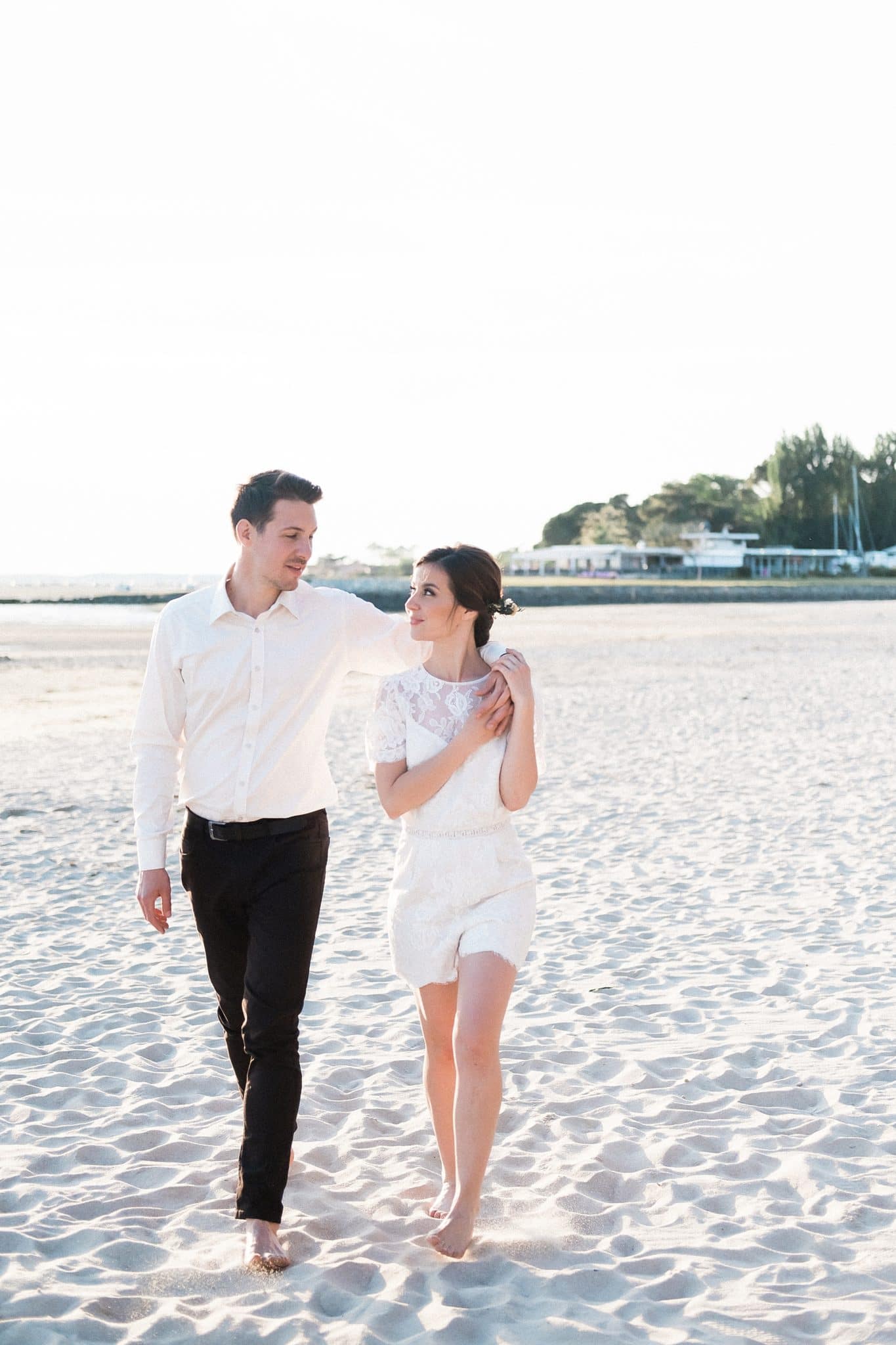 seance couple ou les futurs mariés sont en train de marcher dans le sable au bord de la plage a andernos les bains sur le bassin d'arcachon