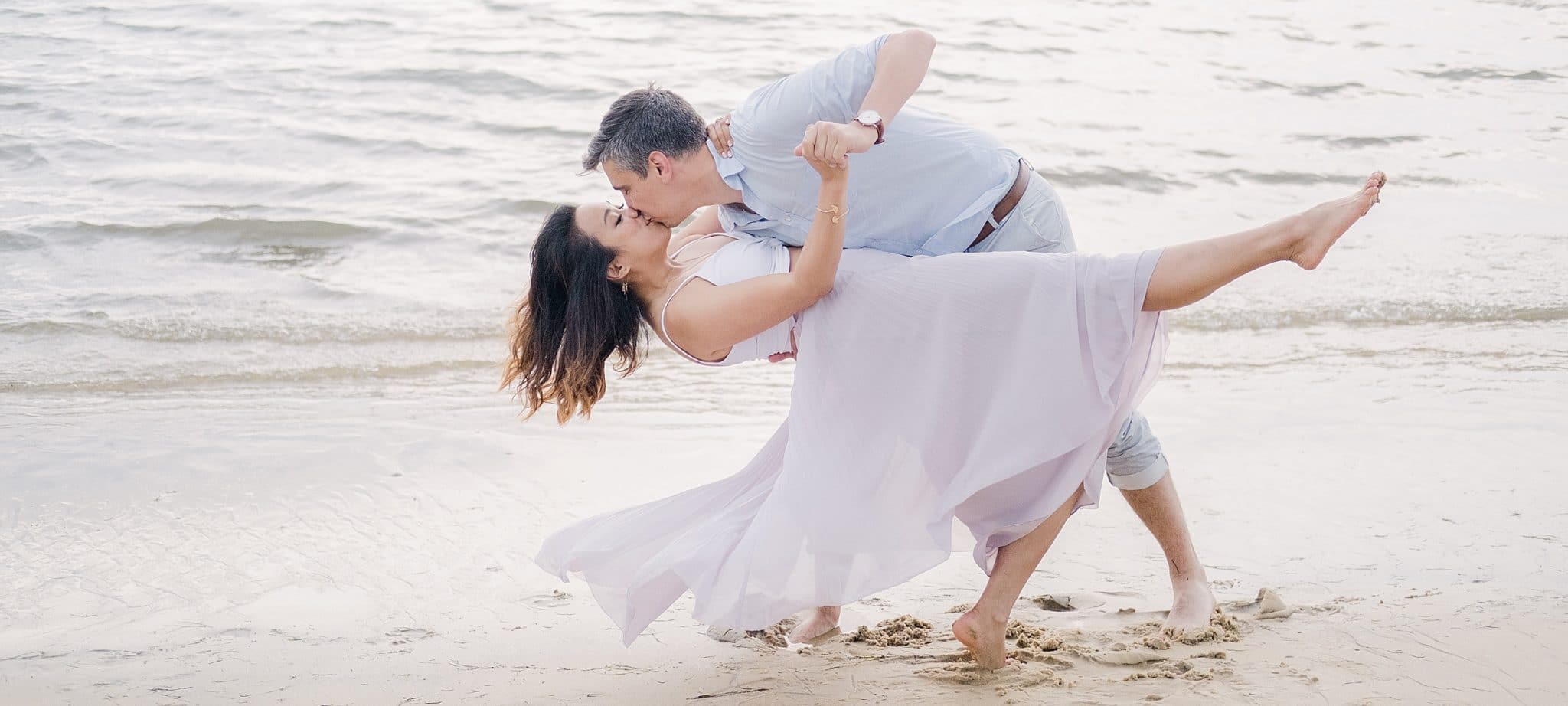 seance couple à arcachon où la future mariés se penche et le marié l'embrasse