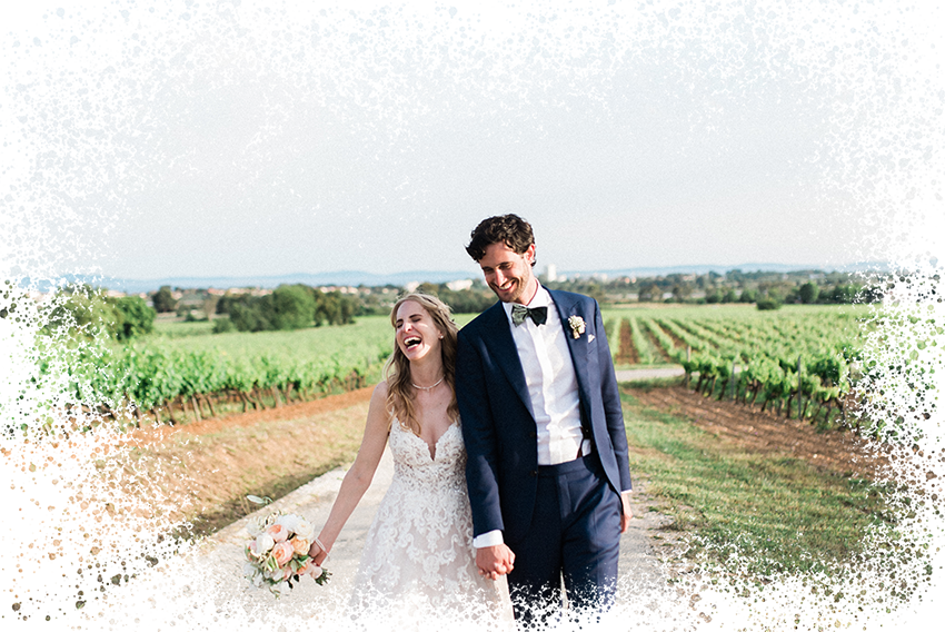 voici un couple se tenant la main en train de marcher et de rire dans les vignes de bordeaux