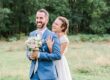 seance couple de mariage en pleine nature avec le marié qui tient le bouquet de fleurs