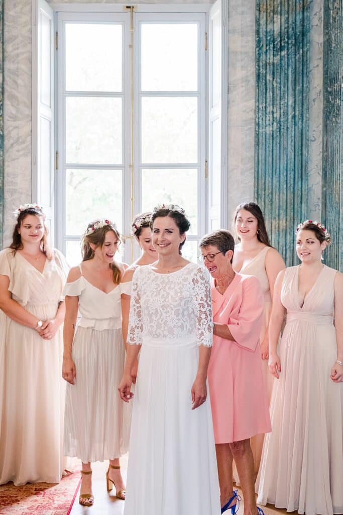 la main de la mariée boutonne la robe de mariée autour de ses témoins