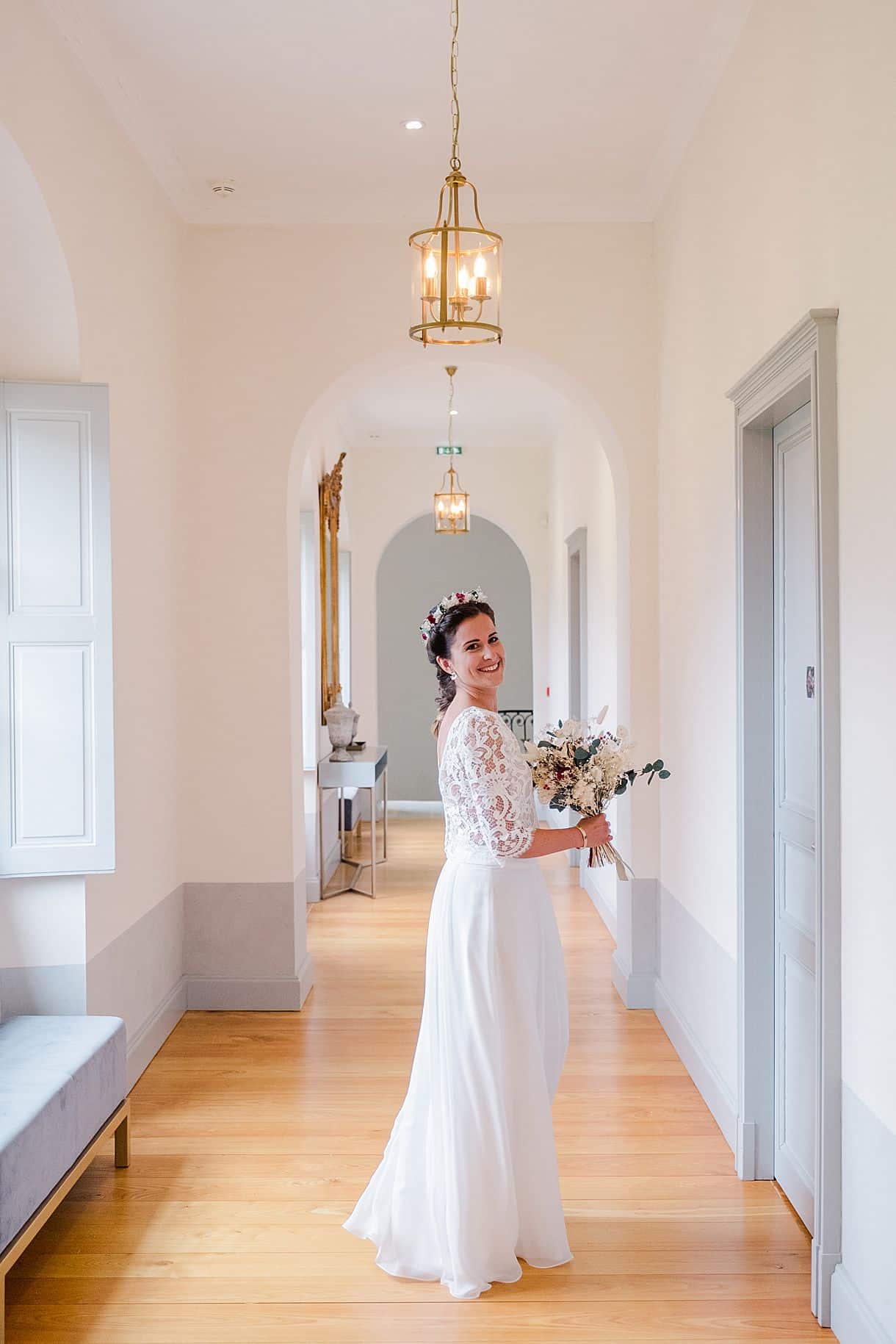 la mariée est dans le couloir des chambres habillée avec sa belle robe en dansant