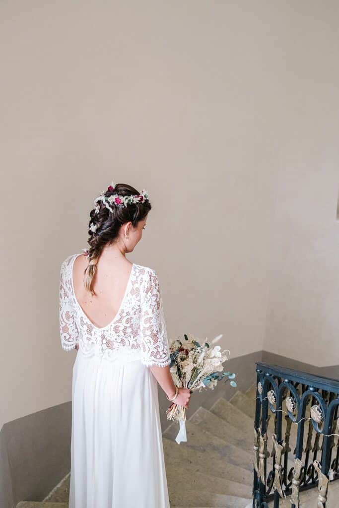 la mariée est de dos et descend les escaliers du chateau de l'hospital