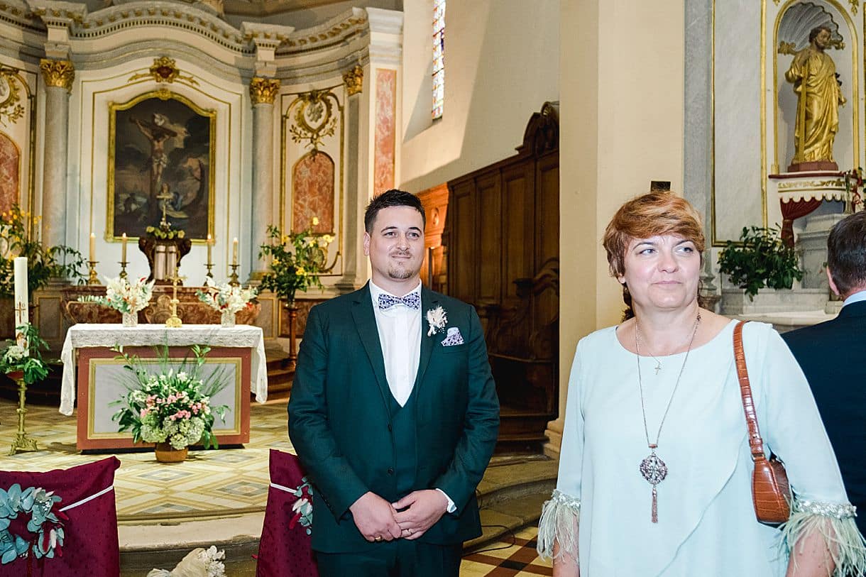 le marié attend impatiemment la mariée qui va s'approcher pour rentrer dans l'église de Portets en gironde
