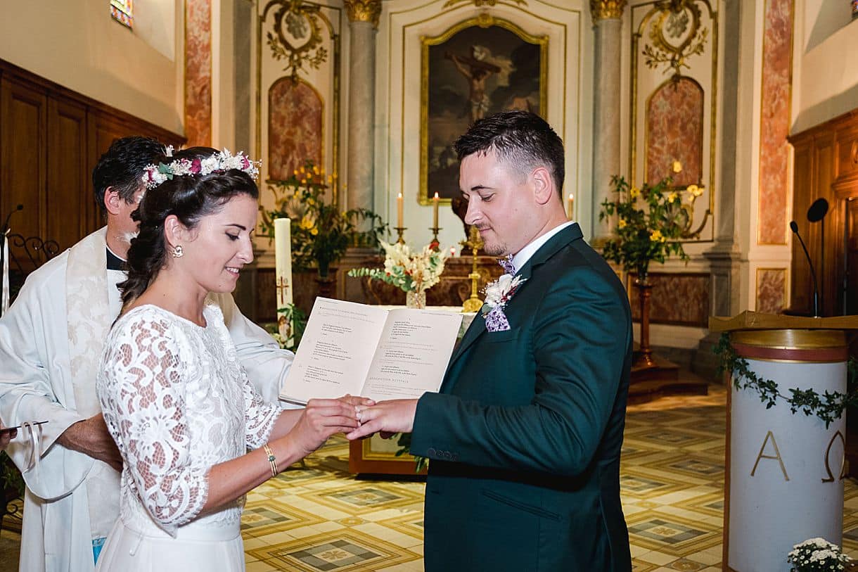 la mariée met la bague au marié dans l'église de Portets en Gironde