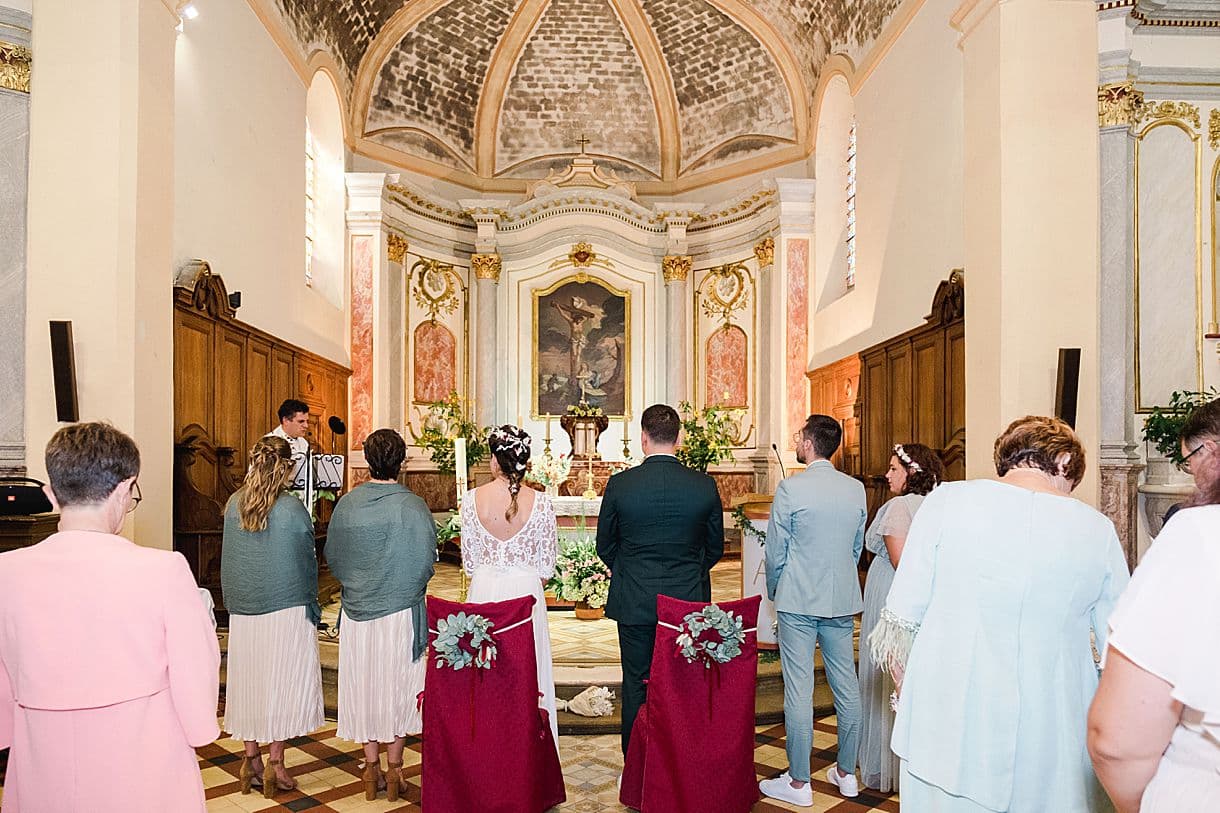 les mariés ainsi que les témoins sont de dos lors de la cérémonie de mariage dans l'église de Portets