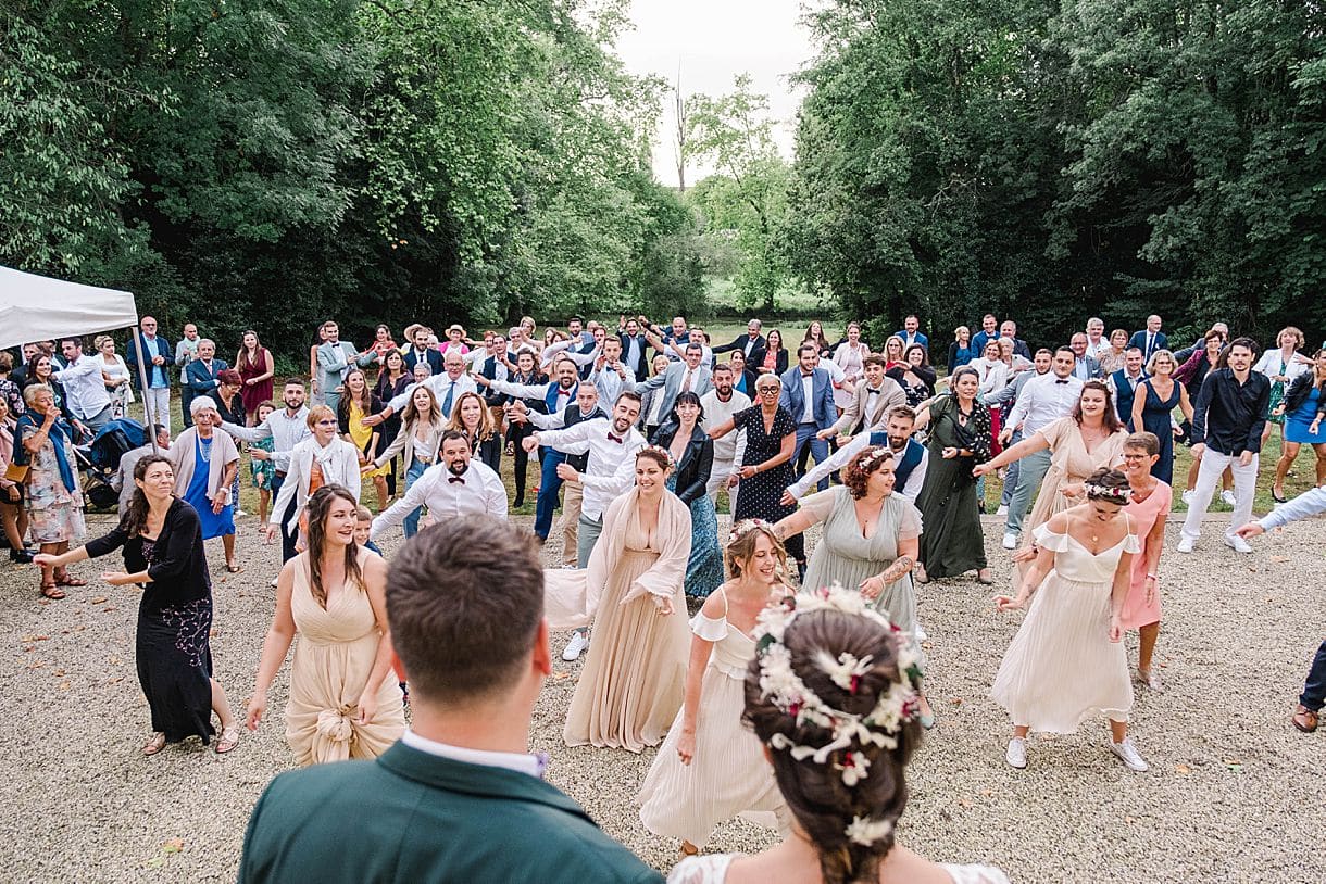 vue de dos des mariés avec le flashmob de l'ensemble des amis et des invités