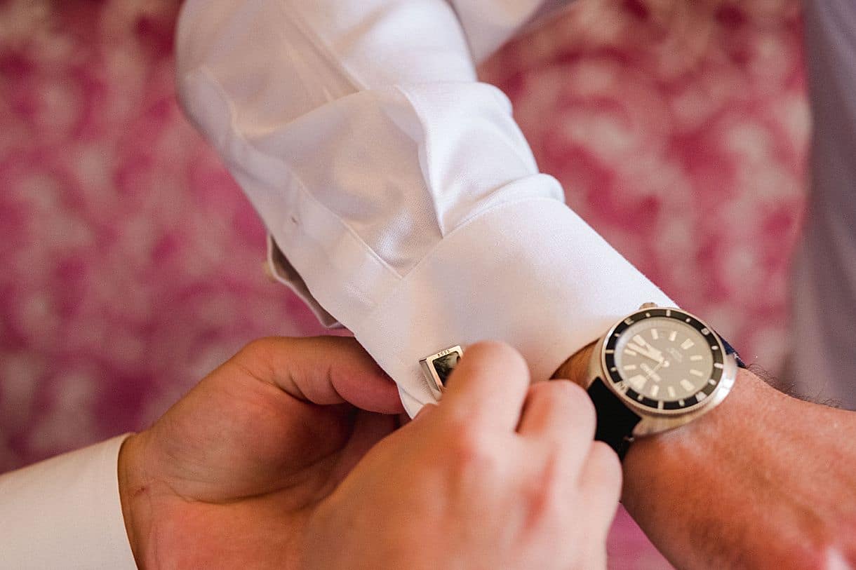 détail de la montre du marié ainsi que son bouton de manchette