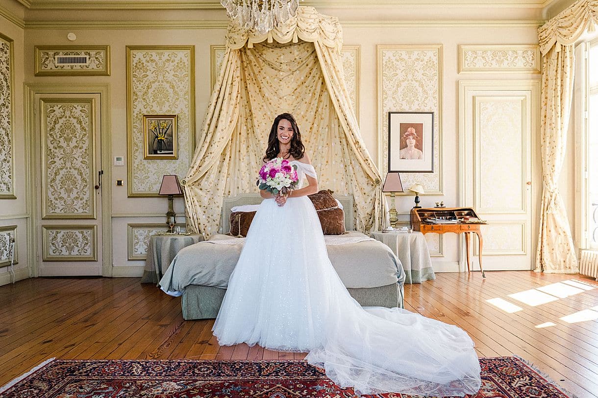 photo de la mariée dans sa chambre avec sa belle robe et son magnifique bouquet de fleurs