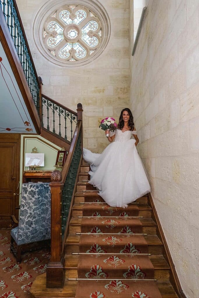 la mariée descend l'escalier pour rejoindre son futur mari