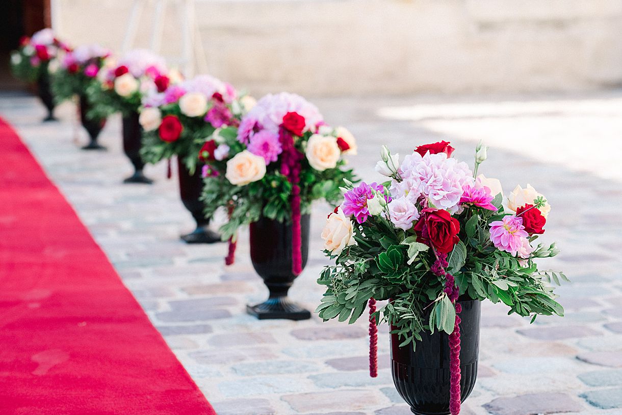 détail des bouquets de fleurs posé par terre à côté du tapis rouge au château pape clément