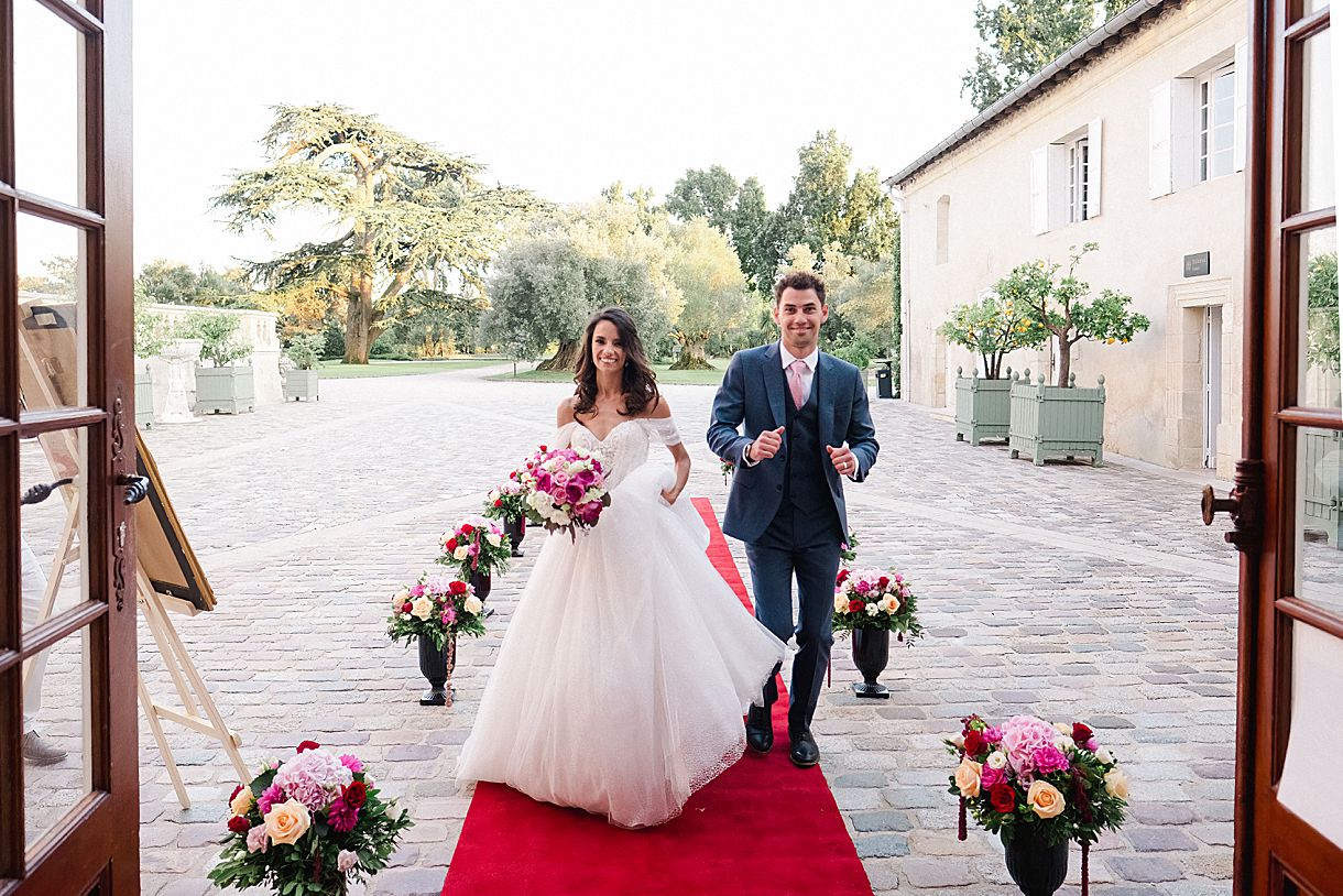 l'entrée des mariés sur le tapis rouge qui va rentrer dans la salle de réception au château pape clément