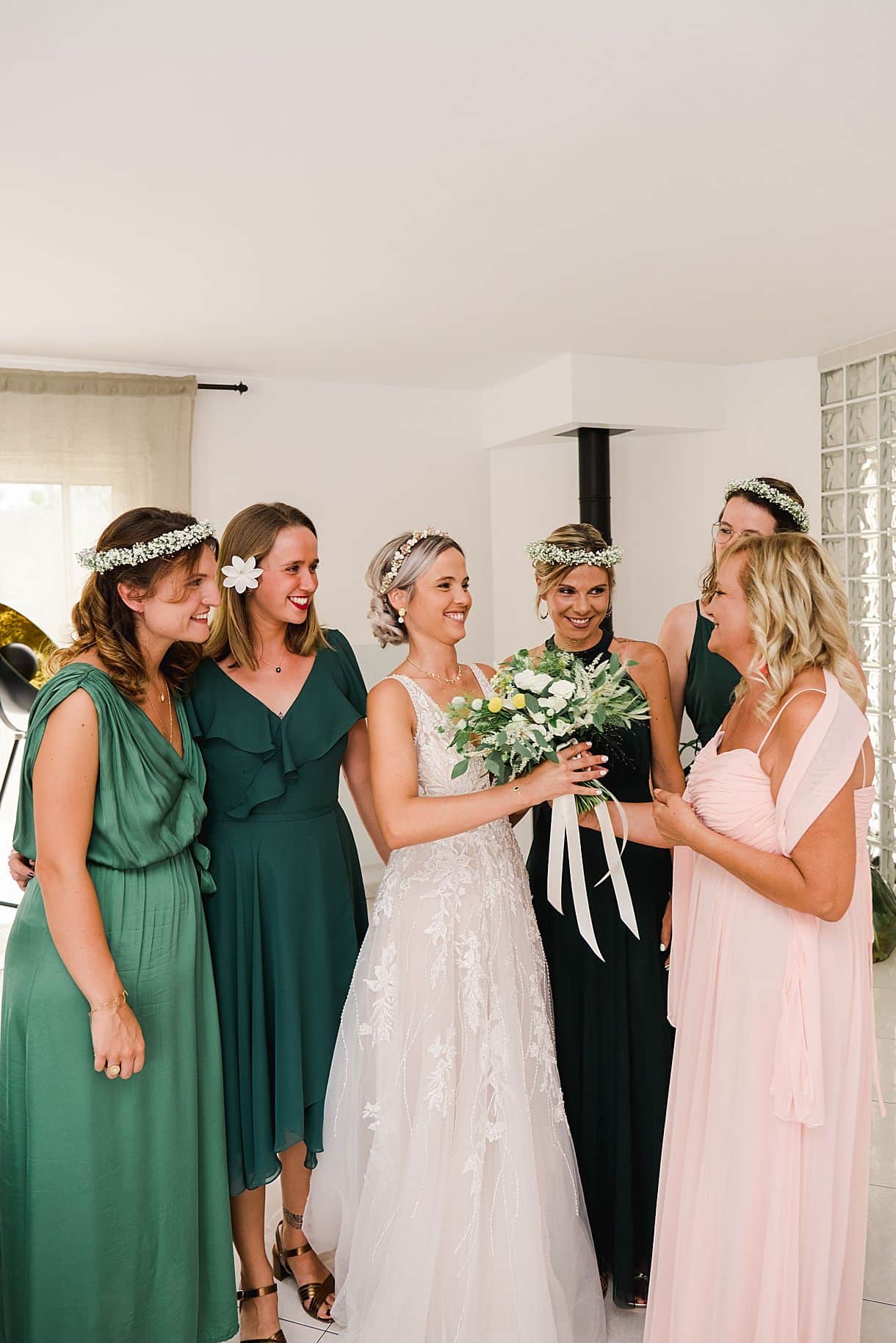 la maman de la mariée apporte le bouquet de fleurs à la mariée entourée de ses témoins pendant ses préparatifs