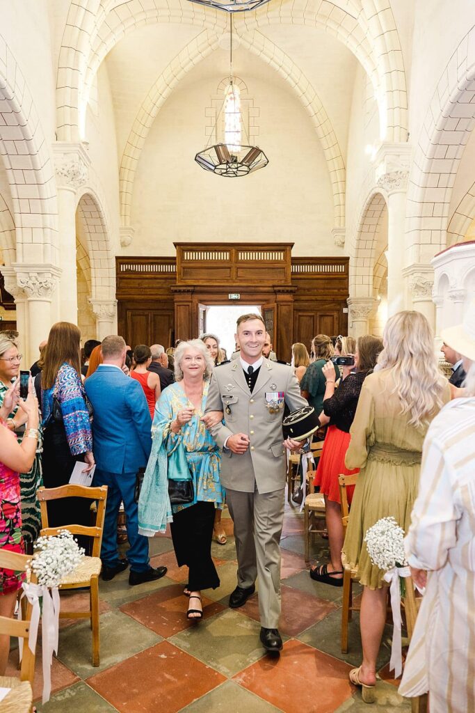 voici l'entrée du marié dans l'église au bras de sa maman