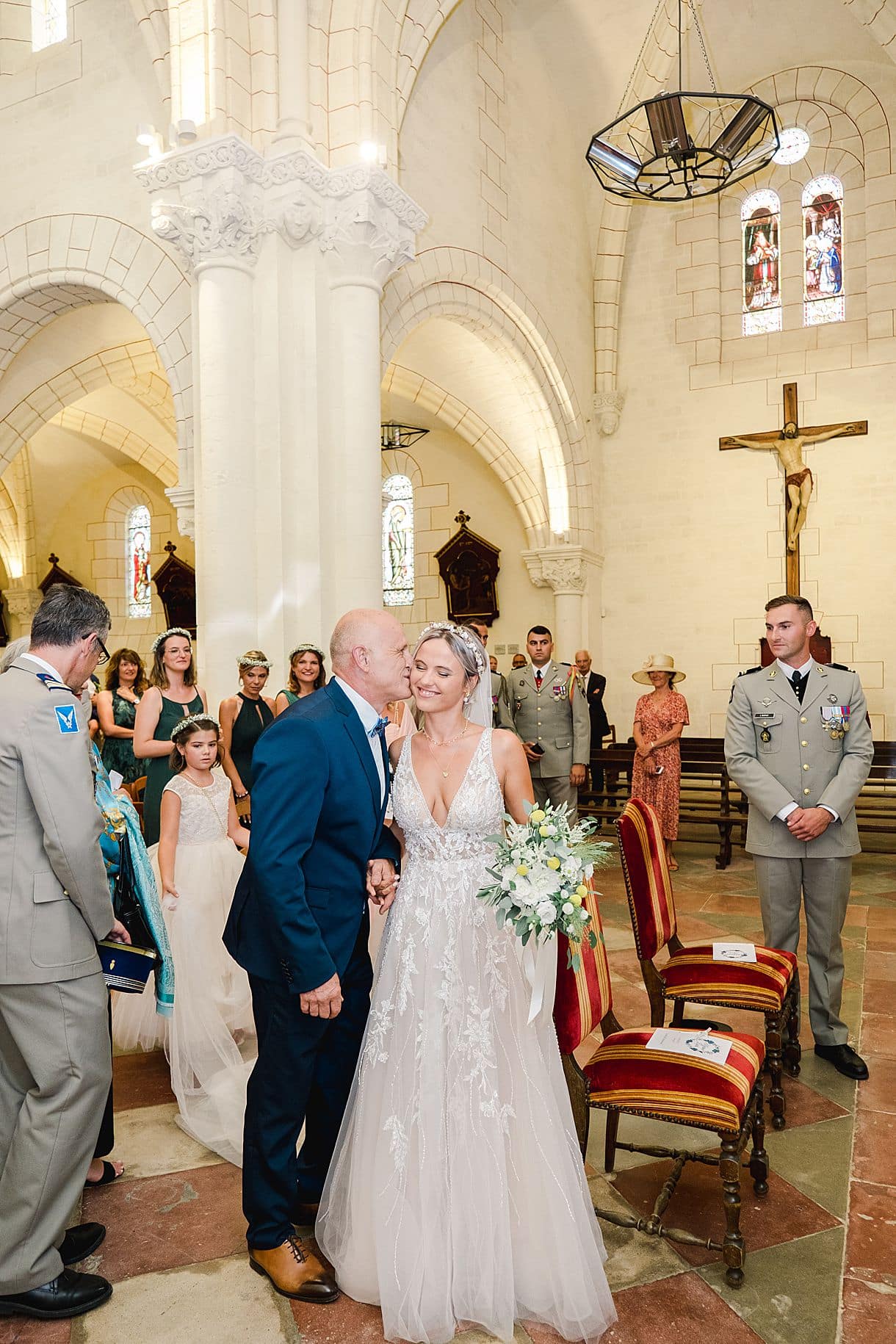 le papa de la mariée est en train de l'embrasser dans l'église