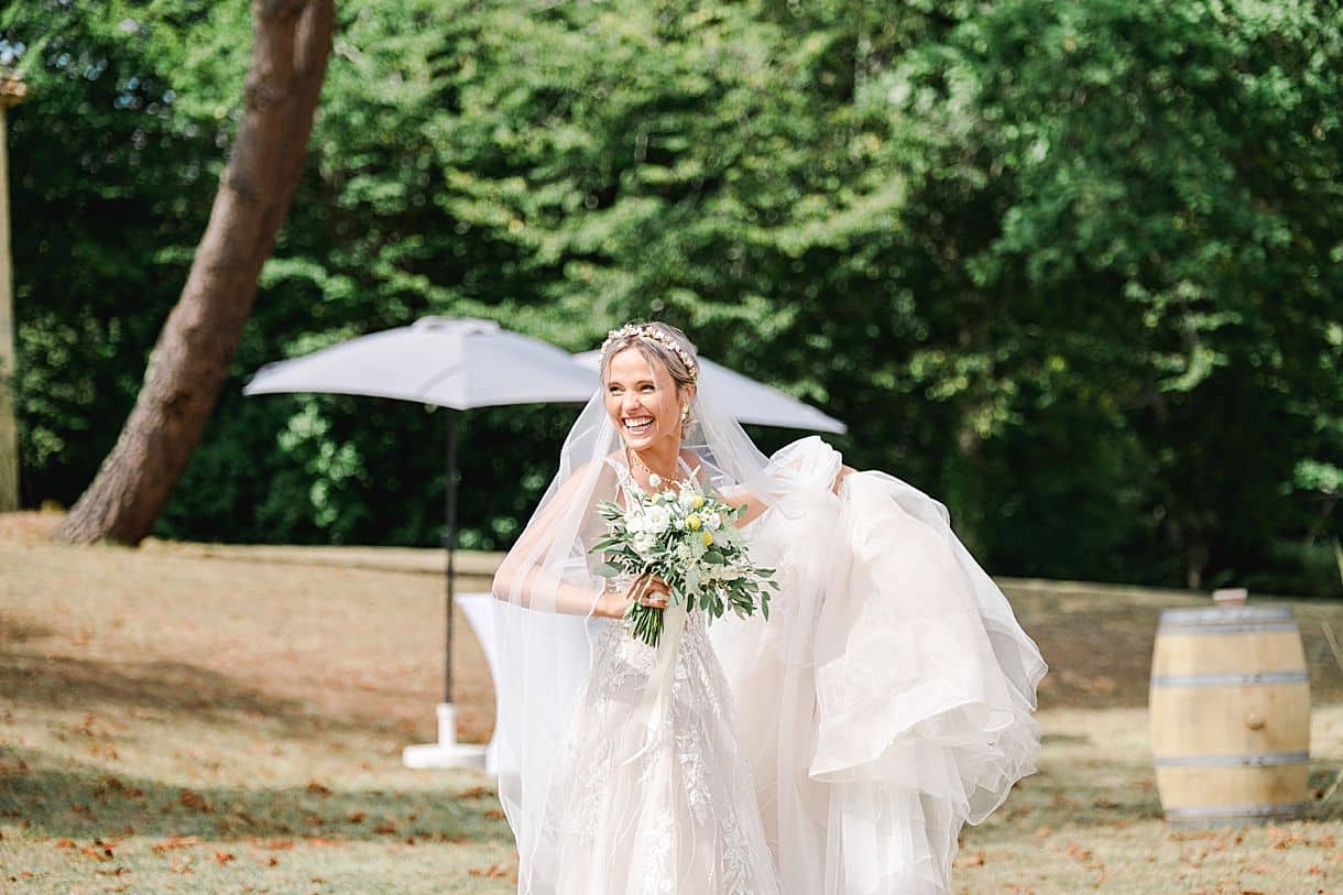 la mariée soulève sa robe en train de sourire au chateau de birot