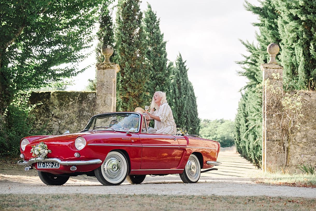 le papa du marié recule la voiture de collection dans l'allée du chateau de birot photos prise par julien boyer