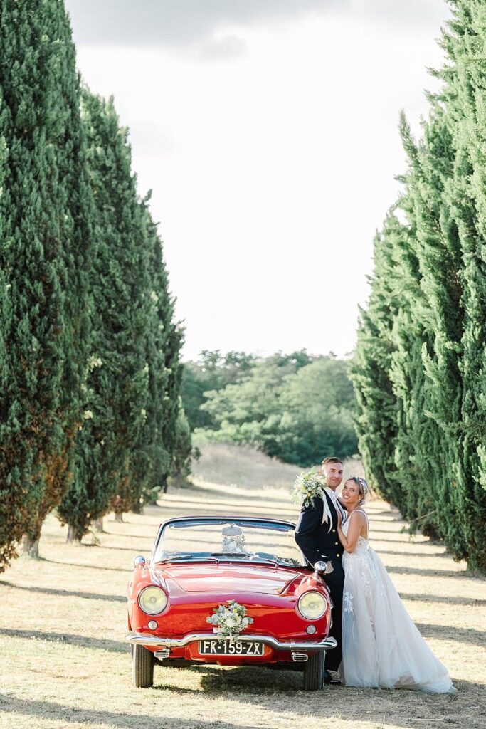 les mariés sont proche en train de regarder julien boyer photographe de mariage à bordeaux proche de leur voiture