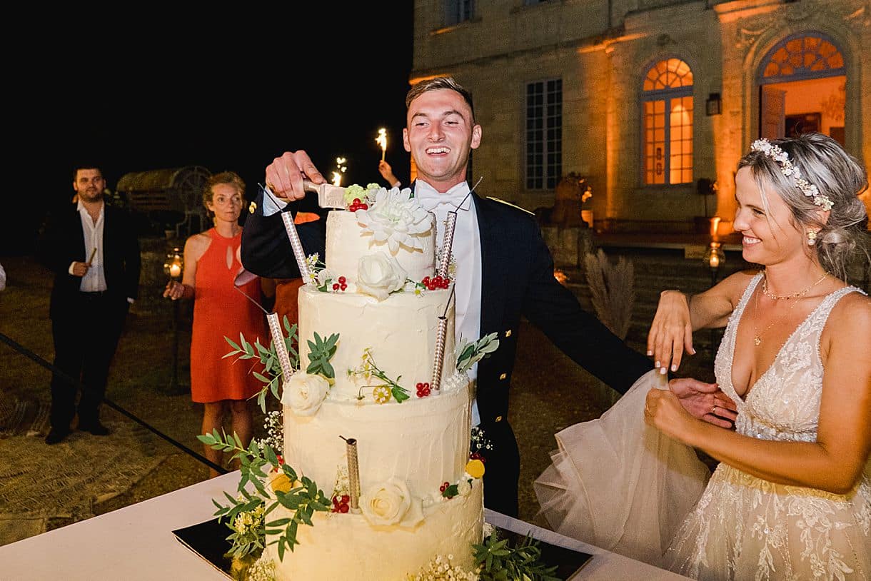 le marié découpe le gateau accompagné de la mariée au chateau de birot