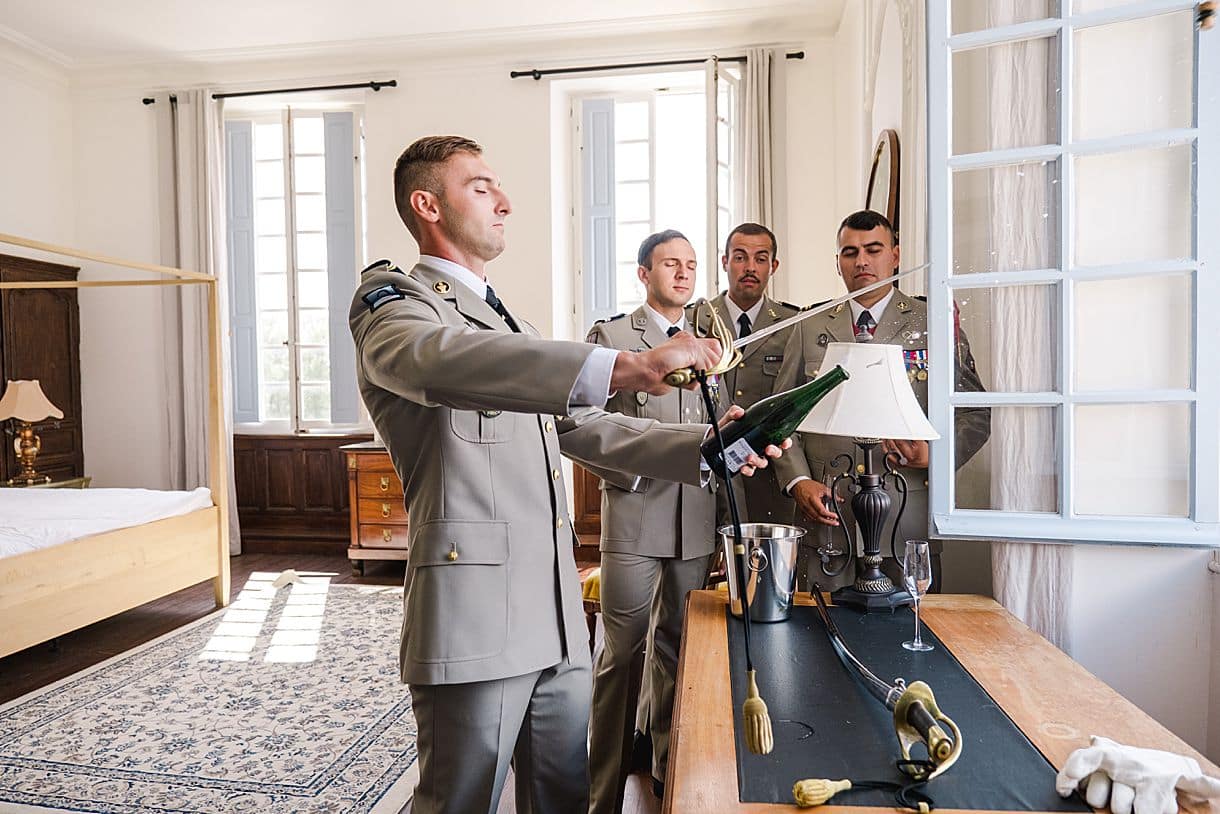 le marié sabre le champagne lors de ses préparatifs au chateau de birot