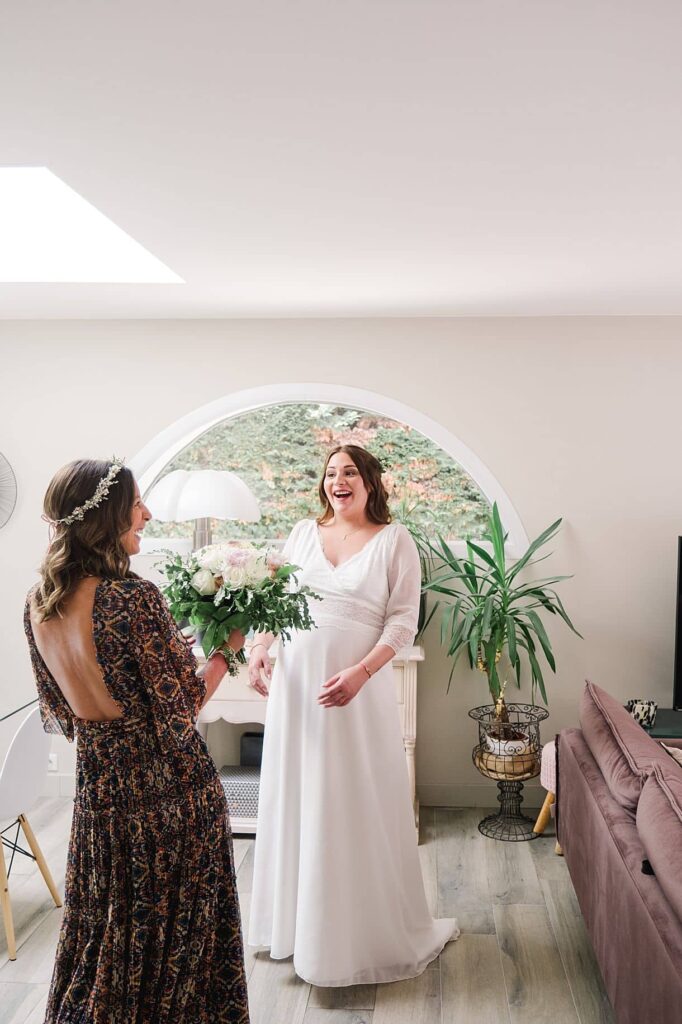 la témoin amène le bouquet de fleur à la mariée