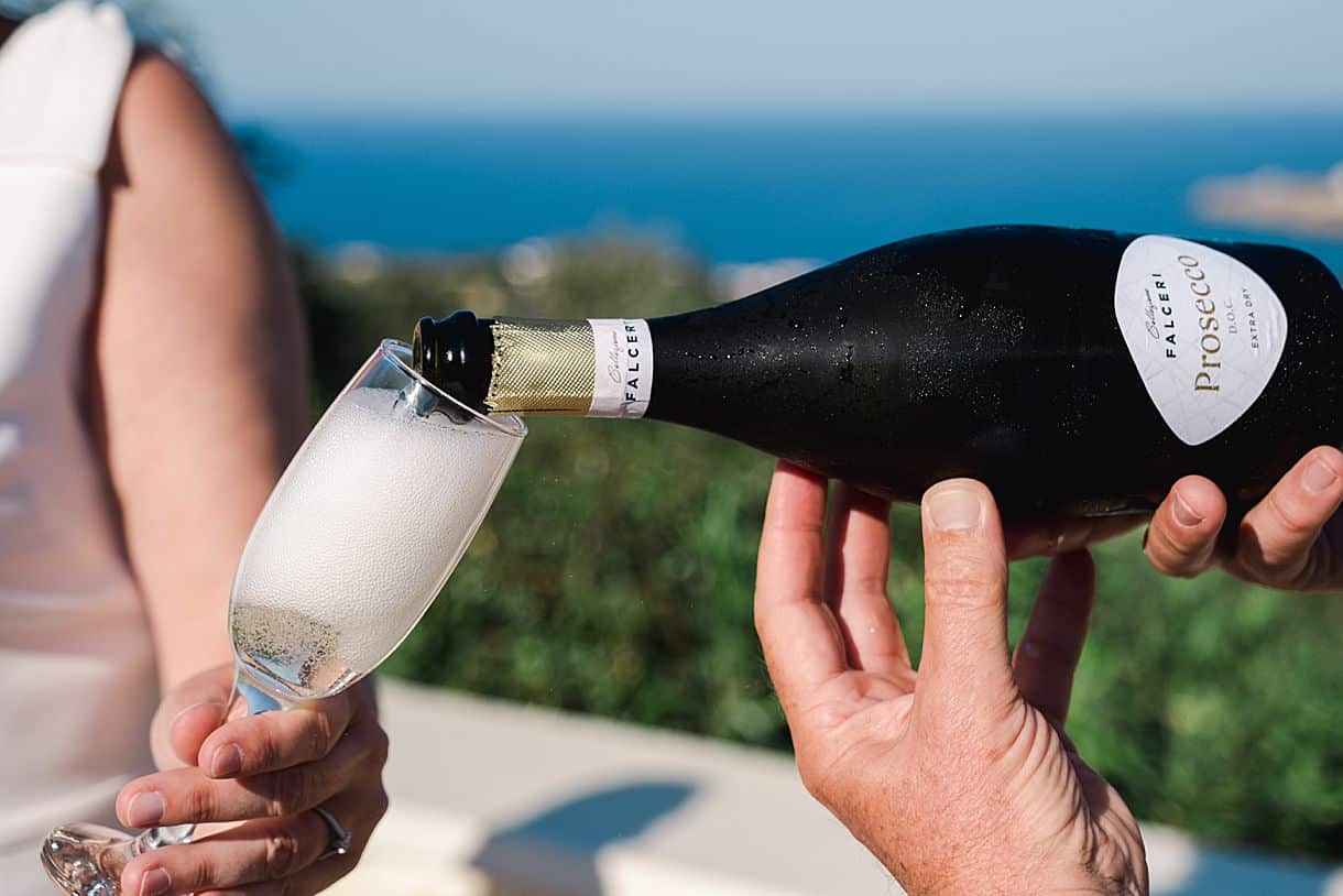 le marié sert une coupe de champagne à la mariée dans leur belle villa luxueuse en crete proche de Reythimnon