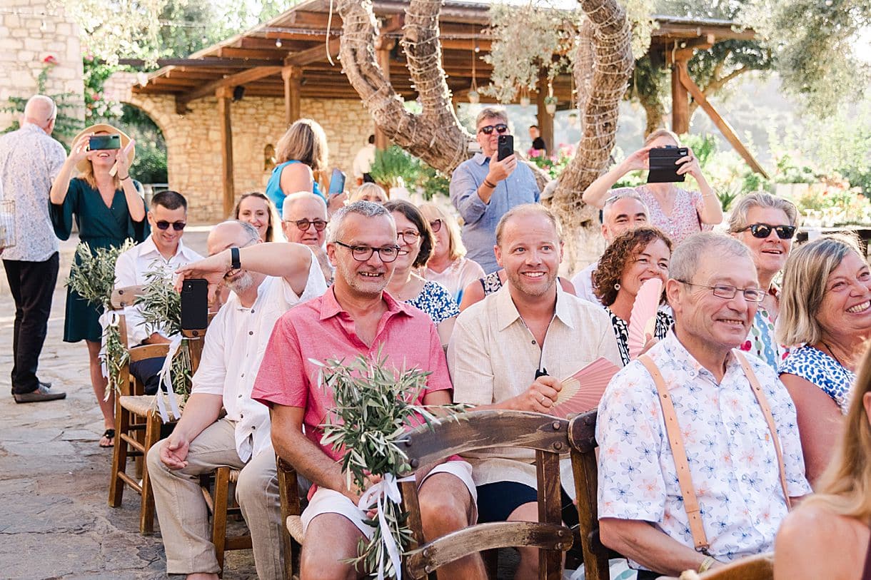 les invités sont heureux lors de la cérémonie laïque de bernadette et françois à l'agrecofarms en crete