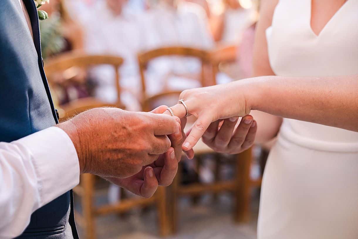 le marié passe la bague au doigt à la mariée lors de leur cérémonie laïque à l'agrecofarms en crete