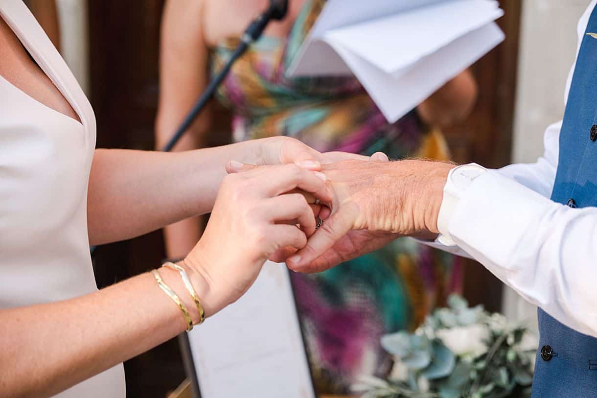 la mariée passe la bague au doigt au marié à la cérémonie laïque lors de leur mariage à l'agrecofarms en crete