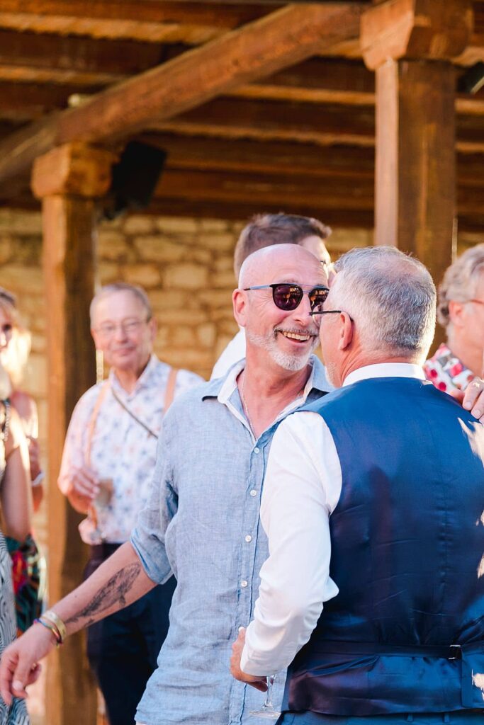 le témoin du marié rigole avec le marié pendant le mariage de bernadette et francois à l'agrecofarms en crete