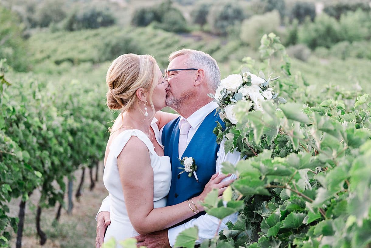 photos des mariés en train de s'embrasser dans les vignes cretoise lors de leur mariage à l'agrecofarms en crete