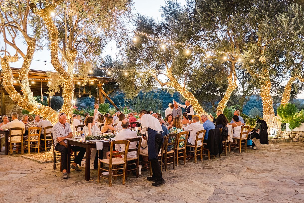 le marié lève son verre avec l'ensemble de ses invités pour trinquer à leur mariage à l'agrecofarms en crete. Photos prise par julien boyer de pixaile photography