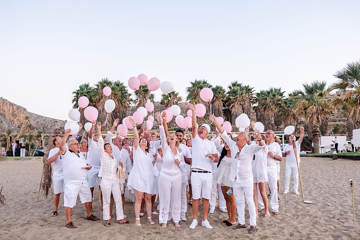 lancé de ballon rose et blanc lors du mariage de bernadette et françois en crête sur une plage