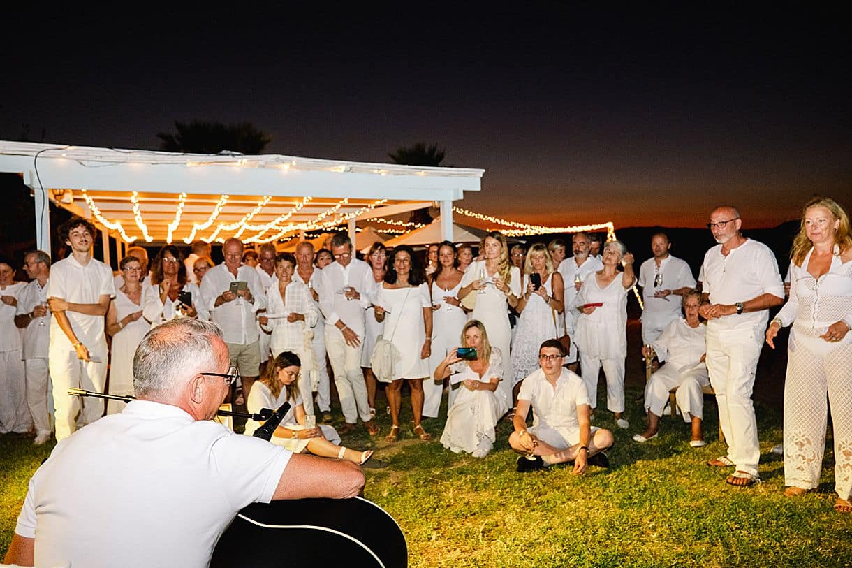 le marié jouent un morceau de guitare pour ses invités lors de son mariage en crête