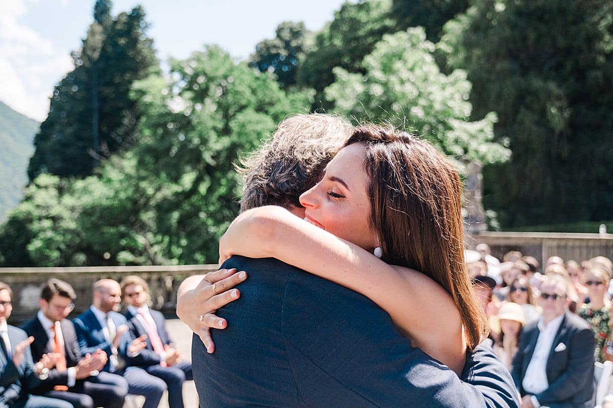 la mariée prend dans les ses bras son papa après la fin du discours lors de la cérémonie laique au lac de come à la villa pizzo photo par julie boyer destination photographer wedding