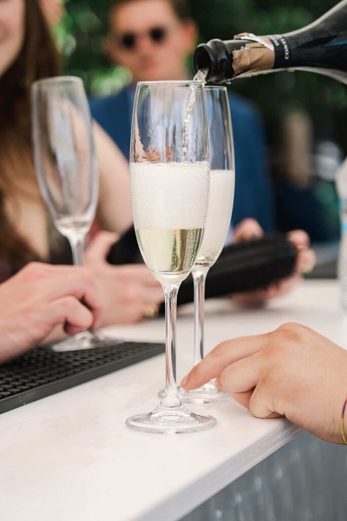 détails du traiteur qui sert le champagne dans un verre lors d'un mariage au lac de come à la villa pizzo